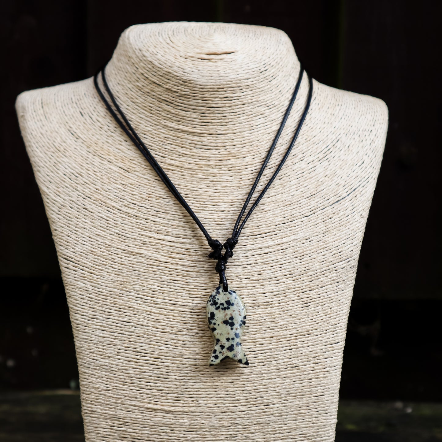 Necklace with a dalmatian jasper fish pendant on a mannequin bust.