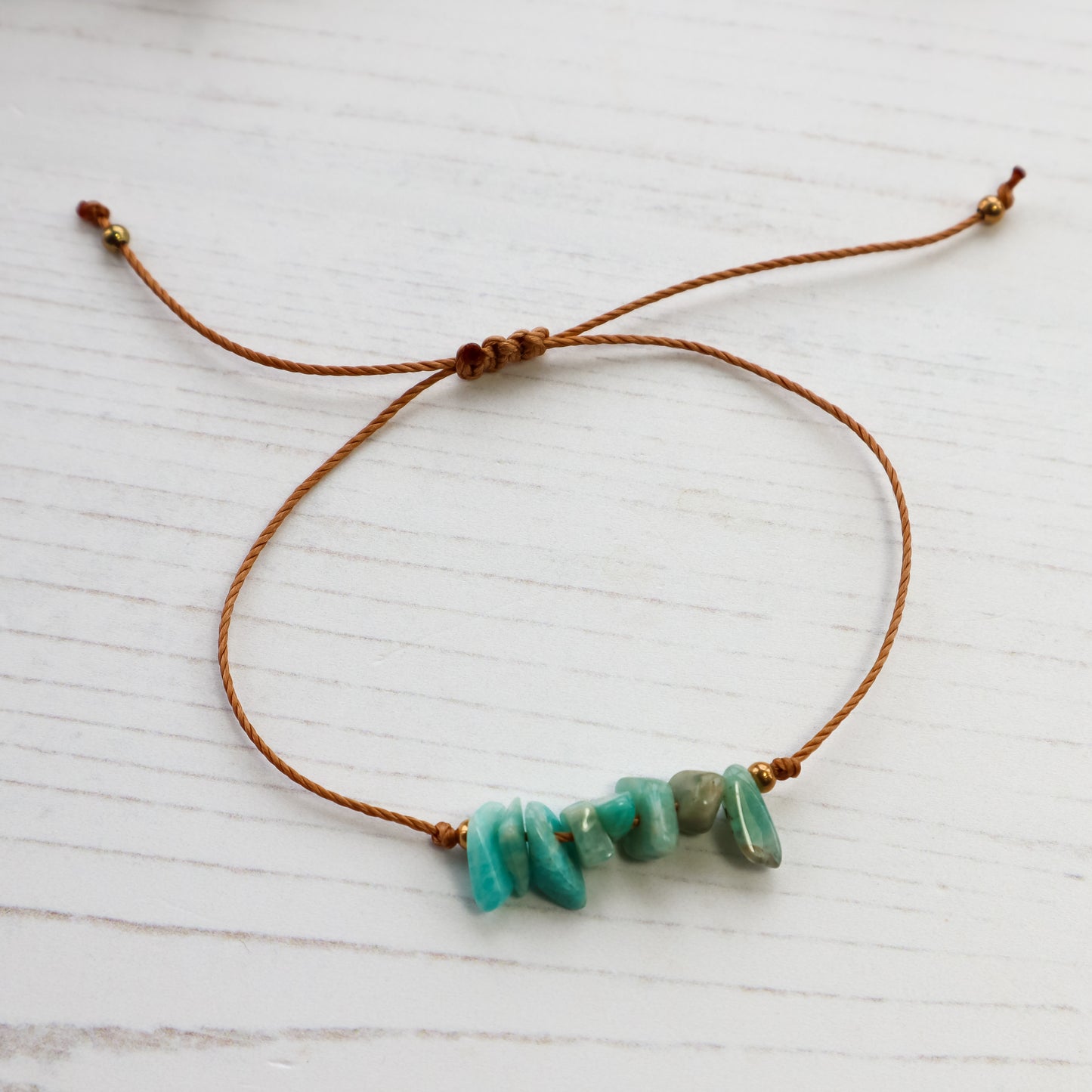 Bracelet with turquoise beads on a white wooden surface