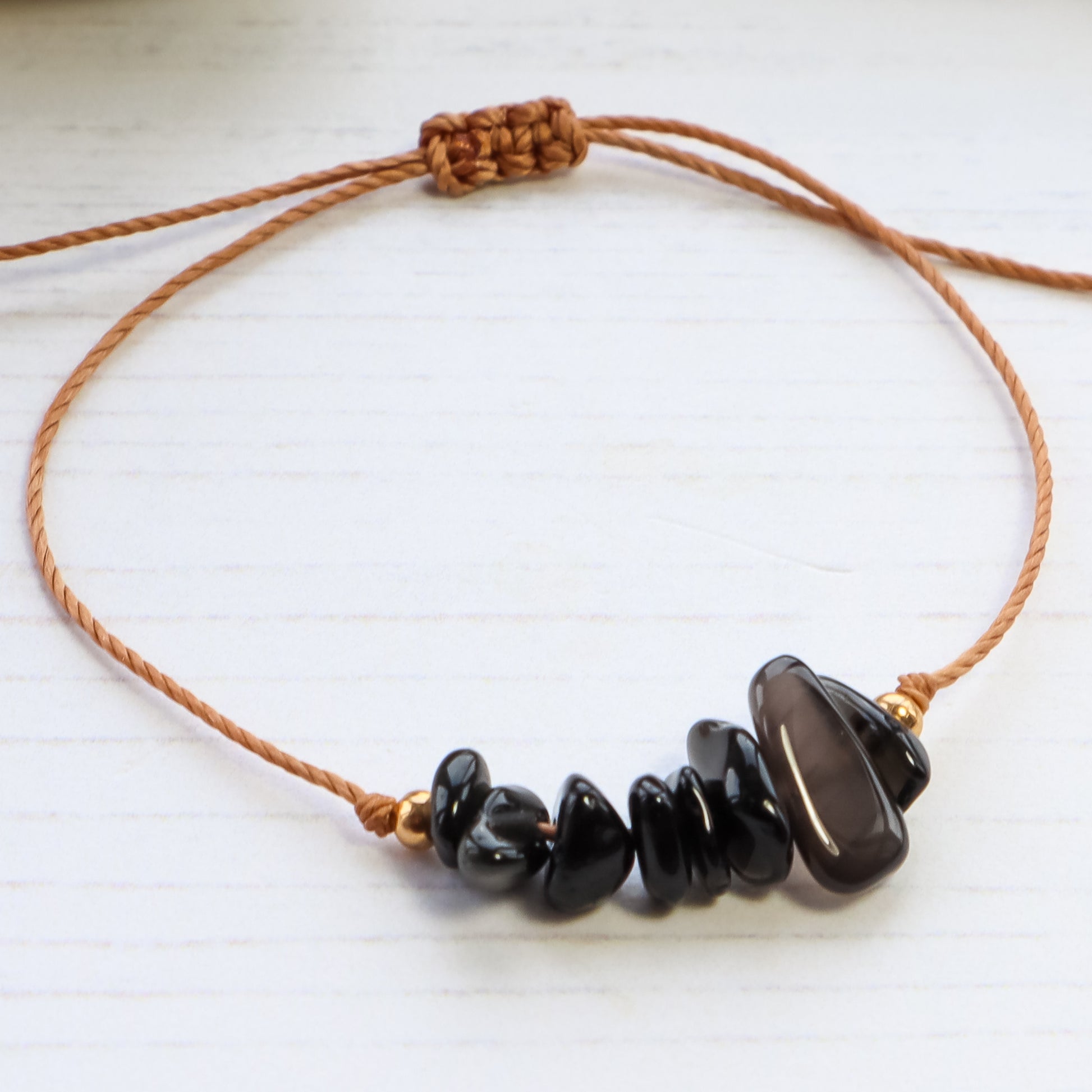 close up of Bracelet with black chip crystals on white wooden background 