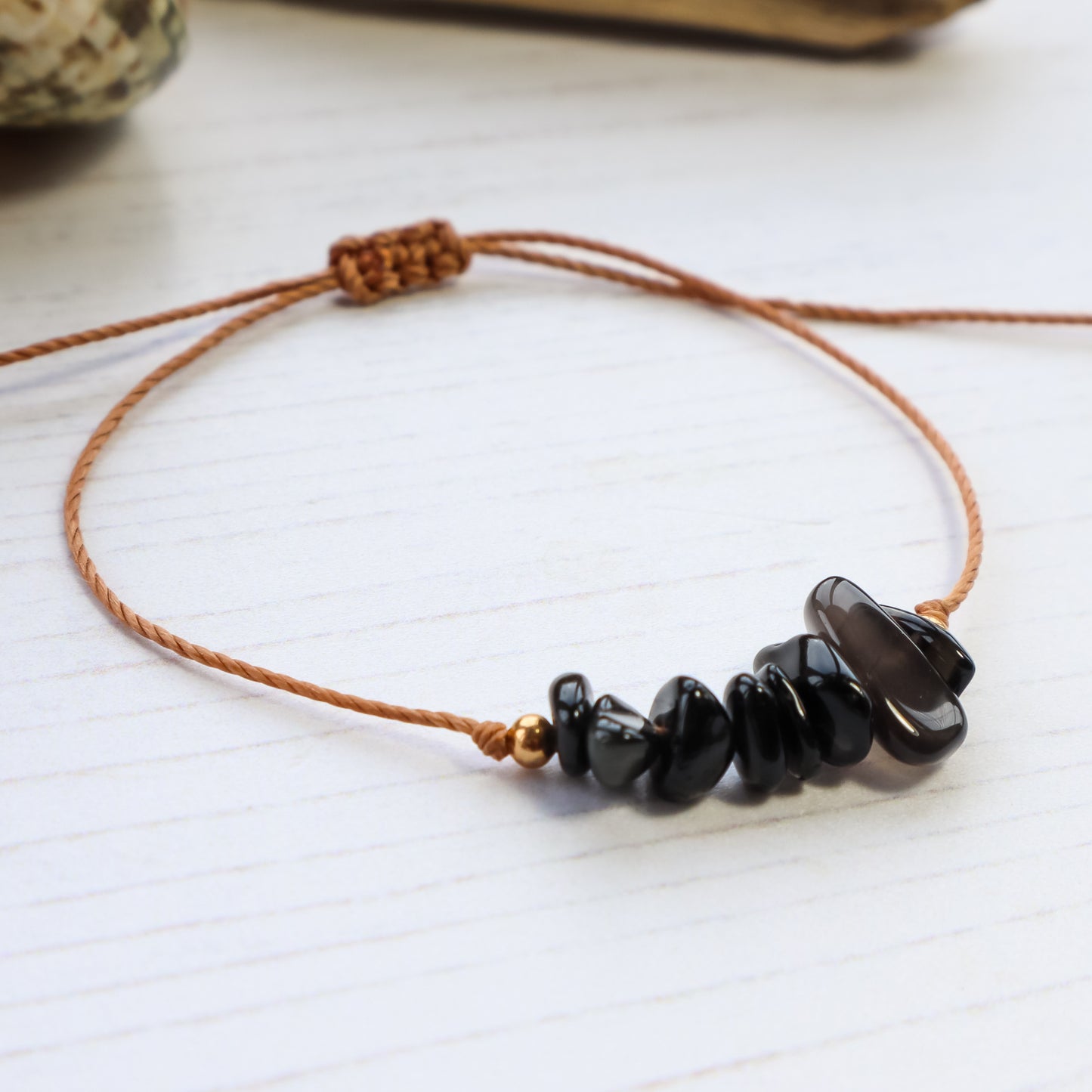 Bracelet with black chip crystals on white wooden background