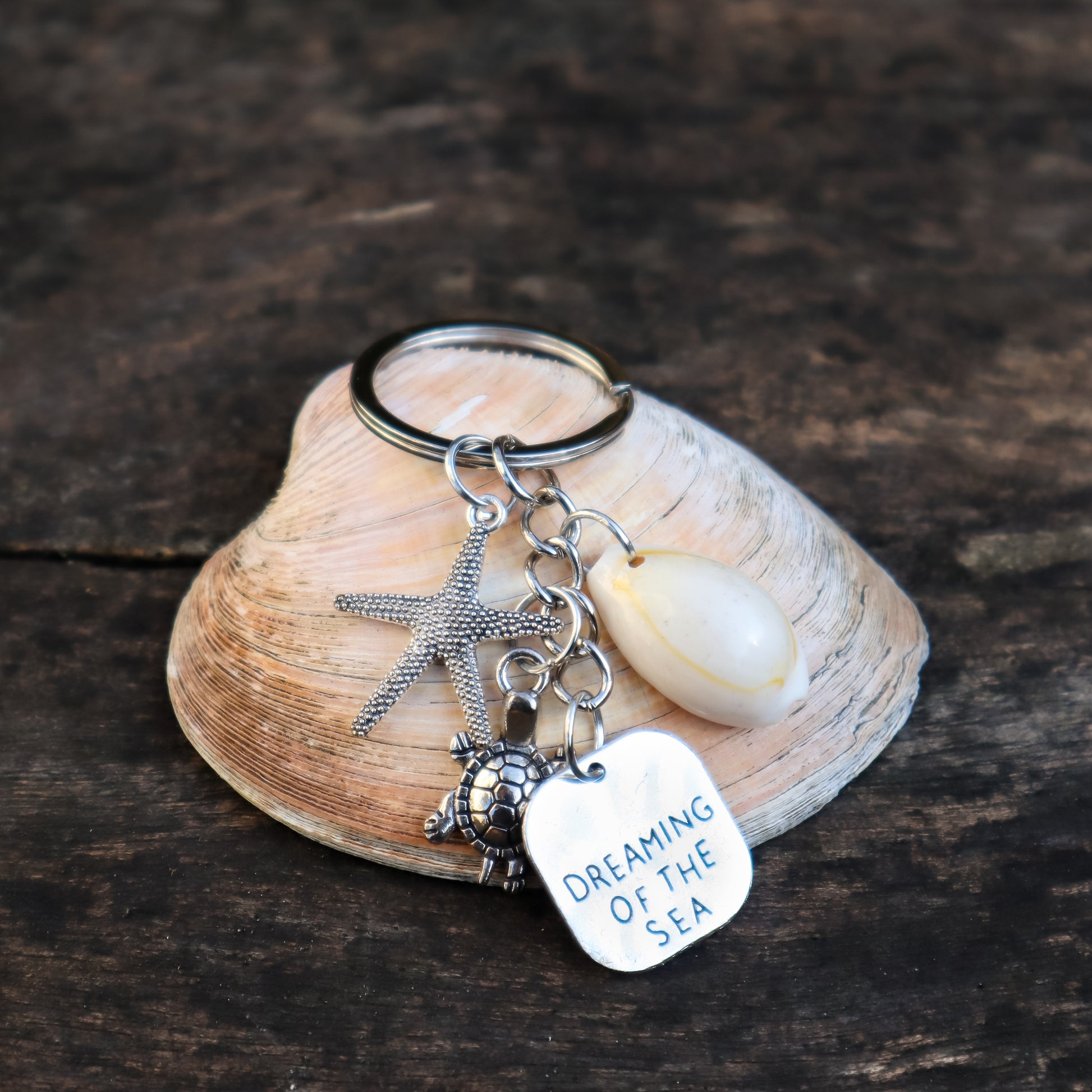 Keychain with charms on a shell against a wooden background