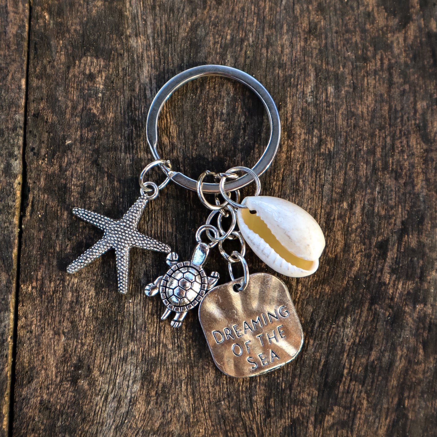 Keychain with starfish, turtle, and shell charms on a wooden surface