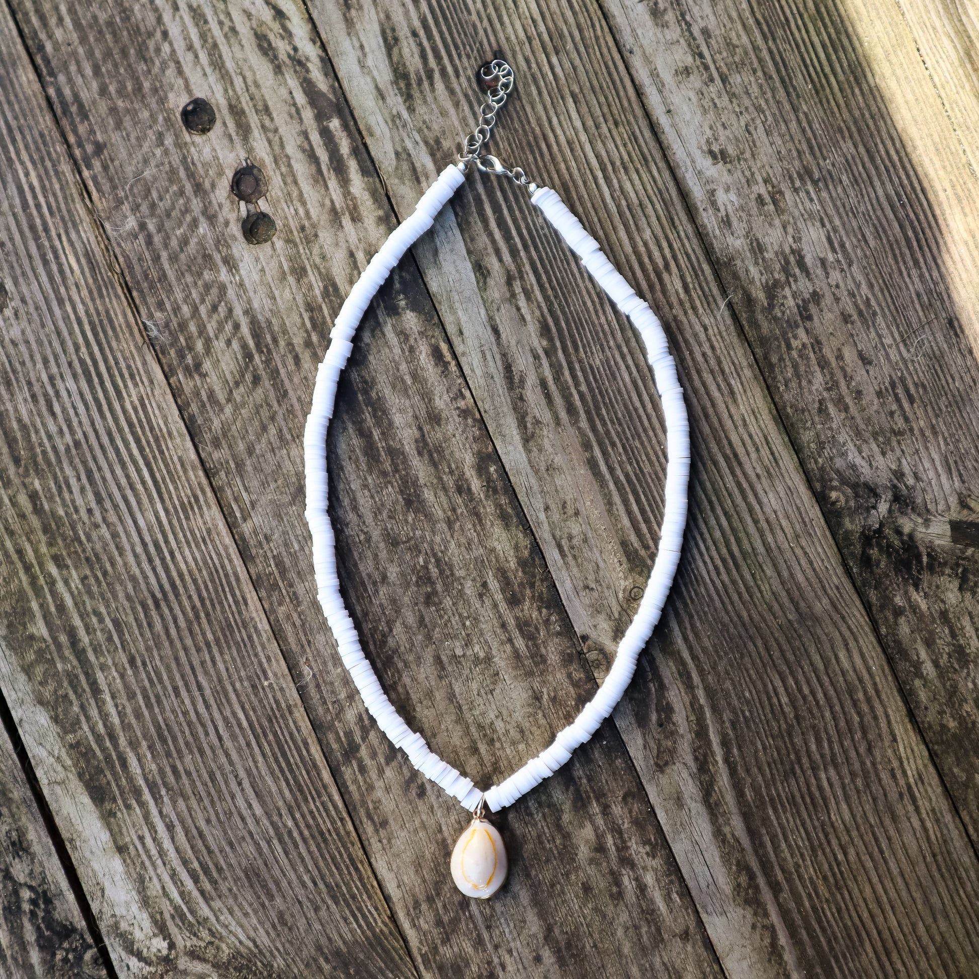 Necklace with a shell pendant on a wooden surface