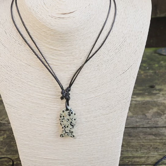 Video of fish pendant necklaces on mannequin and with wooden background . Lapis lazuli and dalmatian jasper fish shaped necklace.