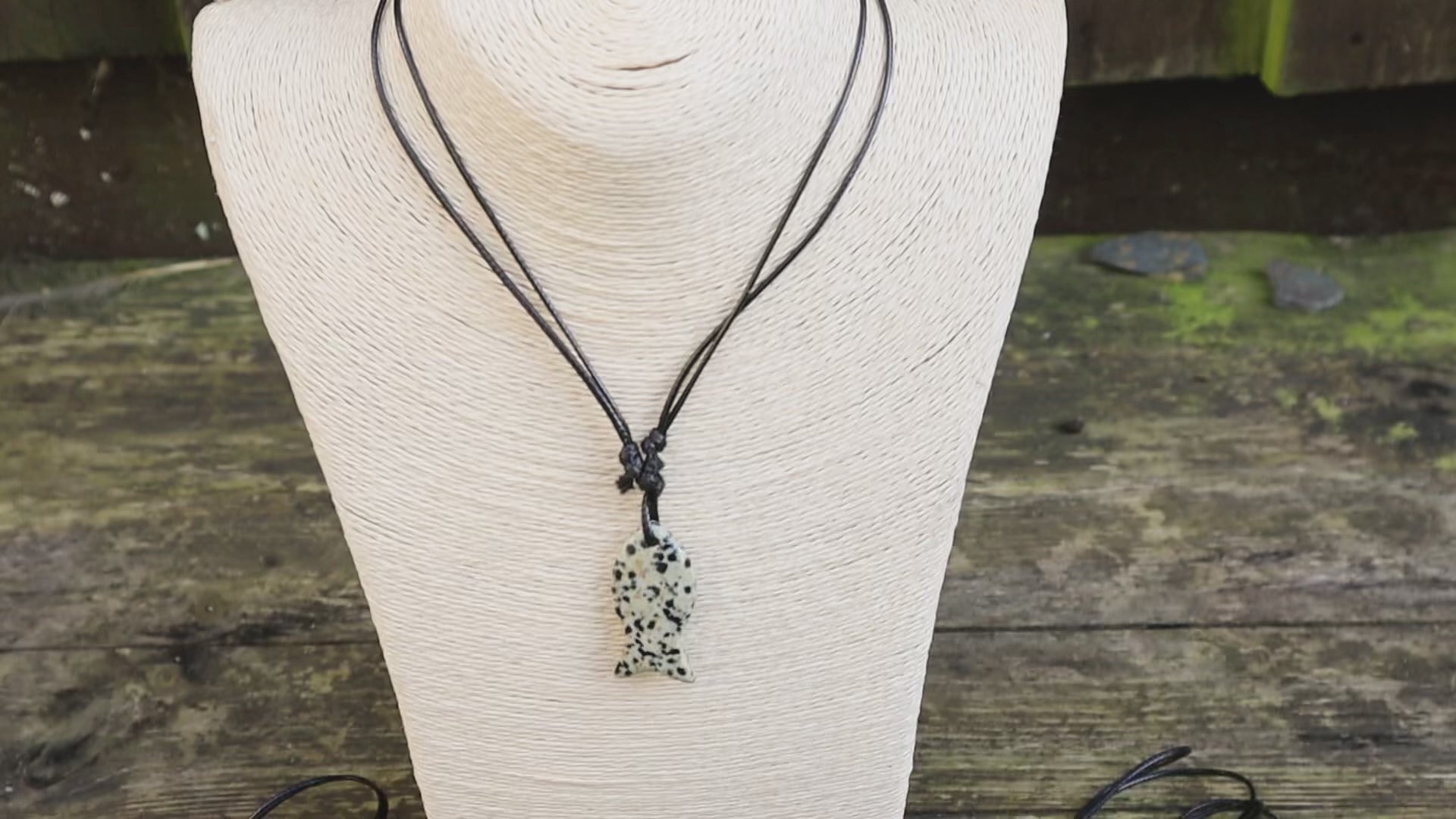 Video of fish pendant necklaces on mannequin and with wooden background . Lapis lazuli and dalmatian jasper fish shaped necklace.